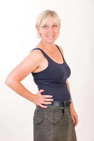 portrait of a attractive blond haired mid aged european woman wearing green skirt and blue top showing happy face - half body - studio shot on white background.の写真素材