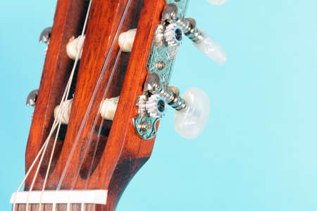 Guitar head with pegs on a blue background isolate