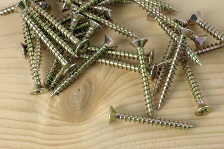 group of wood screws resting on wooden plank