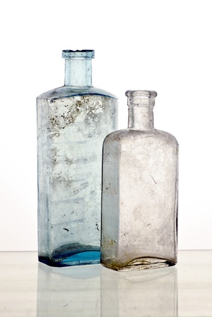 Vintage medicine bottles; two colourless poison bottle; reflections at base of imageの写真素材