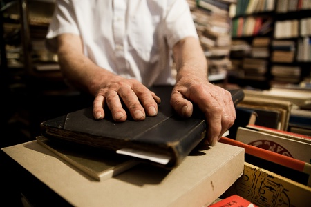 Photo of man in secondhand bookshop and his hands on old booksのeditorial素材