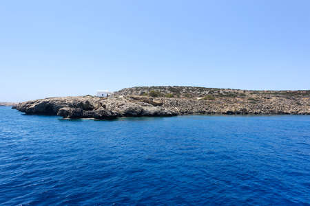Pirate bay in protaras paralimni, white church, blue sea and rocks, cyprus islandの写真素材