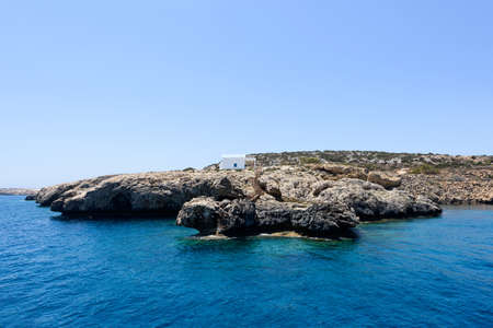 Pirate bay in protaras paralimni, white church, blue sea and rocks, cyprus island
