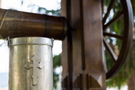 Ancient well with drinking water and a metal bucket with cross sign at Capriana Monastery in Moldovaの写真素材