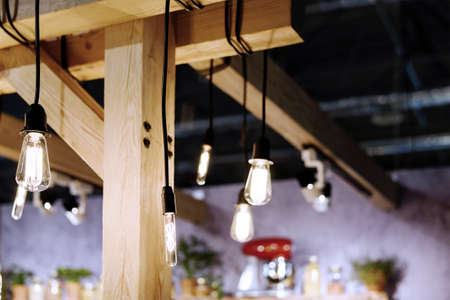 Incandescent light bulbs in a loft style room interior with furniture