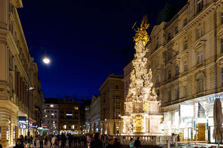 VIENNA, AUSTRIA - MAY 17, 2016: Photo view on memorial plague column pestsaule and tourists on graben street at night with peopleのeditorial素材