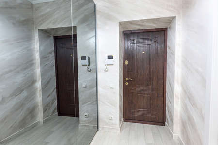Stock photo white apartment interior hall design with brown entrance door and mirror wall, modern style, chisinau, moldovaの写真素材