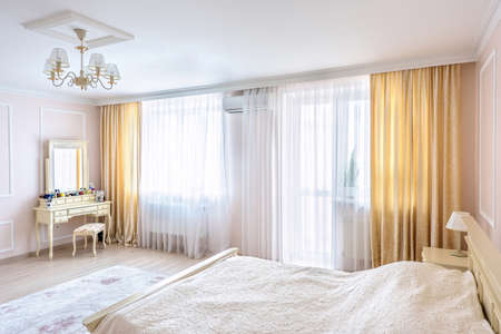 White apartment interior design bedroom with classic furniture, curtains, modern style in chisinau, cenral district, moldovaの写真素材