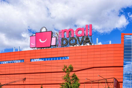 CHISINAU, MOLDOVA - JULY 14, 2017: Shopping centre malldova with red bags logo, blue sky and clouds, sky reflection on glass windowsのeditorial素材
