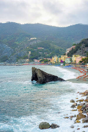 Beautiful view to rock in blue water, city and green mountains. Monterosso al Mare, Italy. Cinque Terreの写真素材