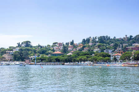 Daylight view to mountains, blue sea, beach pier and city of Rapallo, Italy.の写真素材