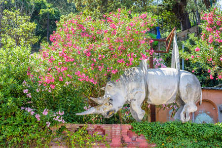Daylight view to suspended Rhinoceros sculpture ornated with flowers. Portofino, Italyの写真素材