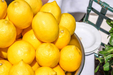 A lot of Yellow fresh lemons in a plate. Closeup photoの写真素材