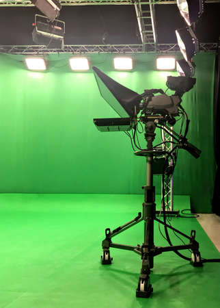 Modern empty green video recording and broadcasting studio with tv channel led screen and metalic stands, text prompter, lights onの写真素材