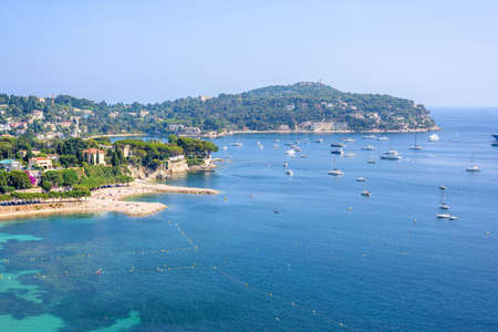 Beautiful daylight view from top of mountains to luxury resort villefranche sur mer and bay on french riviera at mediterranean sea Cote dAzur in France, beach with boats cruising on water.の写真素材