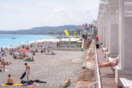 NICE COTE D'AZUR, FRANCE - JUNE 27,2017: Beautiful daylight view to beach resort. Blue water with people walking on sand.のeditorial素材