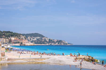 NICE COTE D'AZUR, FRANCE - JUNE 27, 2017: Beautiful daylight view. Blue water with people walking on sand, people fishing.のeditorial素材