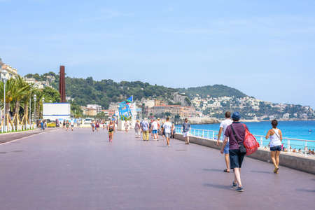 NCIE COTE D'AZUR, FRANCE - JUNE 27, 2017: Beautiful daylight view to city resort. People walking on sidewalk near beach.のeditorial素材