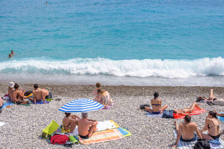 NICE COTE D'AZUR, FRANCE - JUNE 27,2017: Beautiful daylight view to beach resort. Blue water with people walking and relaxing on sand, swimming in water.のeditorial素材