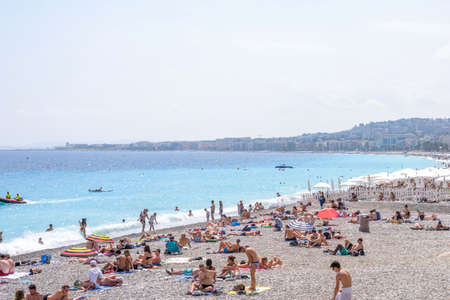 NICE COTE D'AZUR, FRANCE - JUNE 27,2017: Beautiful daylight view to beach resort. Blue water with people walking on sand.のeditorial素材