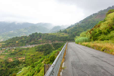 View from road to beauty of Monterosso al Mare, Cinque Terre, Italy. Green mountains and parked cars.の写真素材