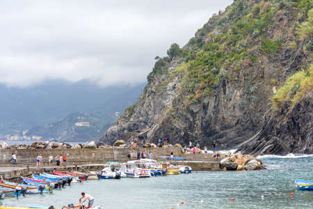 VERNAZZA, ITALY - JUNE 26, 2017: View to little port of city with parked boats and people walkingのeditorial素材