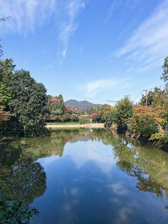 Beautiful daylight view to blue lake with reflection and green park. Kyoto, Japanの写真素材