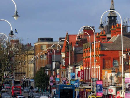Main street with old red brick buildings and cars in southport with blue sky, england, united kingdomのeditorial素材