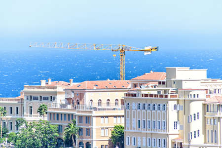 Daylight view to old town with oceanography museum, construction crane, green trees, apartments and buildings. Bright blue clear sky. Negative copy space, place for text. Monte Carlo, Monacoの写真素材