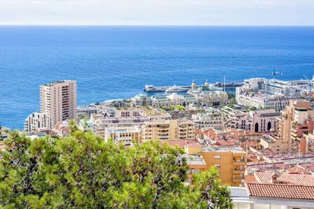 Daylight sunny view to yacht parked in port, luxury buildings and modern houses. Construction cranes working. Bright blue clear sky. Negative copy space, place for text. Monte Carlo, Monacoの写真素材