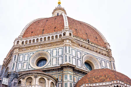Daylight cloudy day view from bottom to ornamented facade of Cathedral Saint Mary of the Flower. Florence, Italyの写真素材