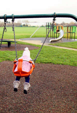 a young child is playing at the playground in winter