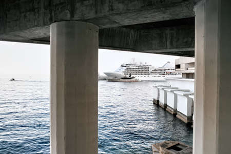 A moored ship and a yacht visible from under the pier in Monacoの写真素材