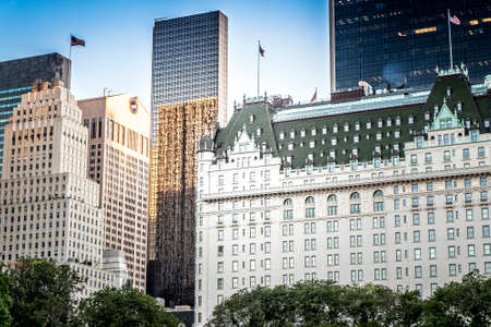 The Plaza Hotel with multiple high buildings on the background in New York, USA. Vibrant colors