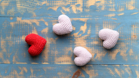 Handmade knitted one red and three pink hearts. Top view