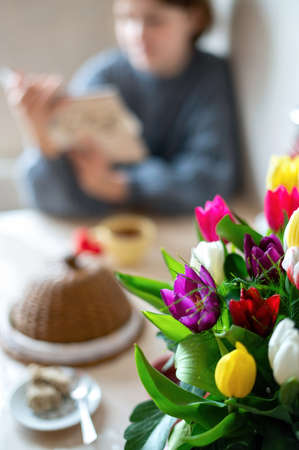Bouquet of flowers with a girl writing on the table. Kitchenの写真素材