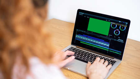 Young content creator girl editing video on her laptop. Working from home