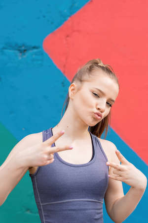 Young blonde woman in sportswear at outdoors training portrait, multicolored backgroundの写真素材