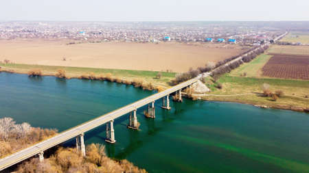 Aerial drone view of a bridge over the floating river and village located near it, fields, fog in the air, Moldovaの写真素材