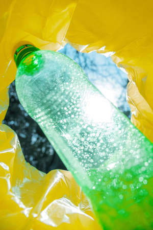 A green plastic bottle inside a trash can. View from inside the canの写真素材