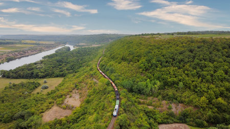 Aerial drone view of nature in Moldova. Moving train near the Dniester river with a lot of greenery...