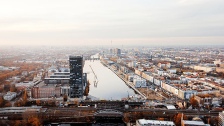 Aerial drone view of Berlin, Germany. District with river, yellowed trees, buildings and Berlin Television Tower in the distanceの写真素材
