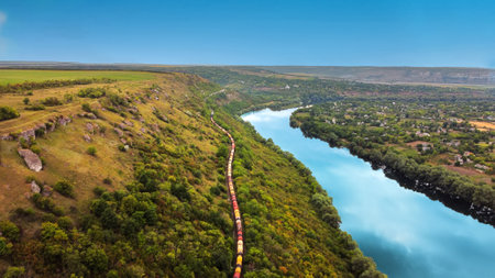 Aerial drone view of nature in Moldova. Moving train near the Dniester river with a village and a lot of greenery aroundの写真素材