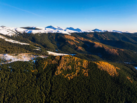 Aerial drone view of Bucegi Mountains in autumn season with snow and blue sky. Romaniaの写真素材