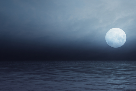 Full moon and transparent clouds over the seaの写真素材