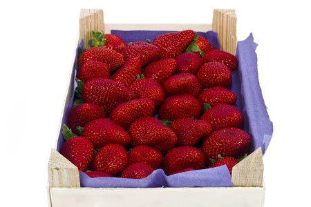 Fresh strawberries in a wooden crate isolated over white の写真素材