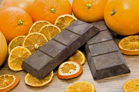 Some oranges and chocolate on wooden tableの写真素材