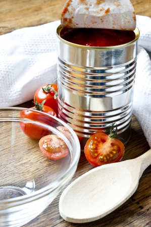 canned raw food and tomatoes on wooden tableの写真素材