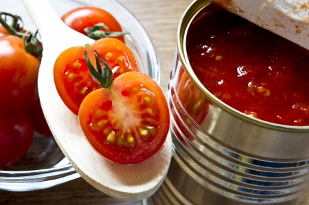 canned tomatoes  and  fresh cherry tomatoes on wooden tableの写真素材