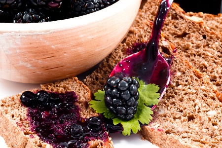 blackberries jam and homemade slices bread on white backgroundの写真素材